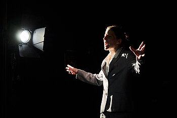 Bild einer Frau auf der Bühne aus dem Stück Prima Facie vom Landestheater