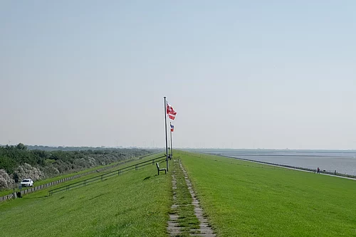 Man steht auf dem Deich und blickt die Deichkrone entlang