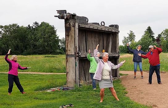 Qi-Gong eine Gruppe führt Qi-Gong-Übungen vor dem Schleusentor aus